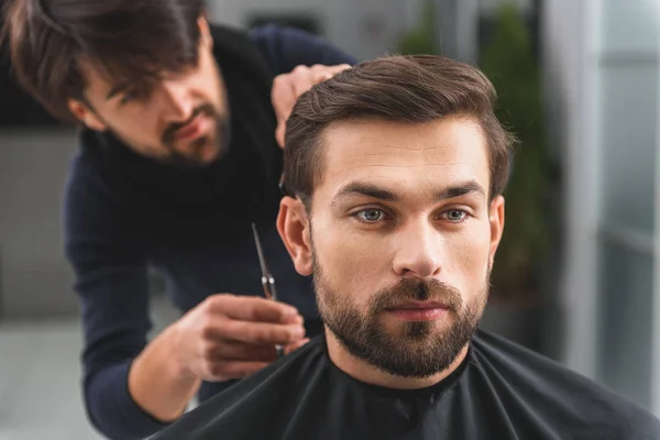 Cara confiante recebendo serviço em cabeleireiros — Fotografia de Stock