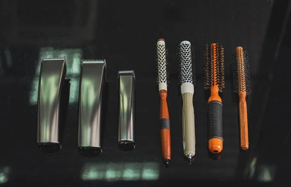 Cortadores e escovas de cabelo diferentes na barbearia — Fotografia de Stock