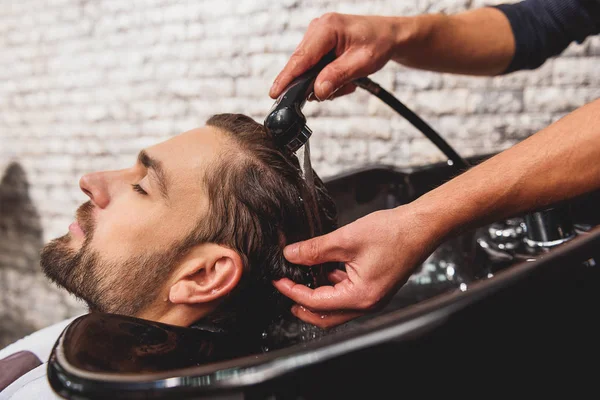 Barbiere professionista che si sottopone a lavaggio dei capelli in salone — Foto Stock