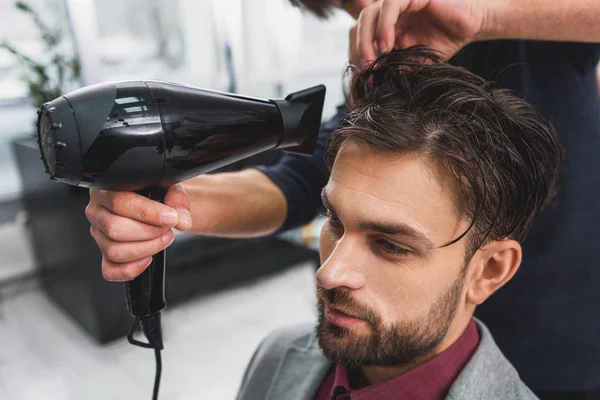 Abile barbiere asciugatura capelli maschili presso il barbiere — Foto Stock