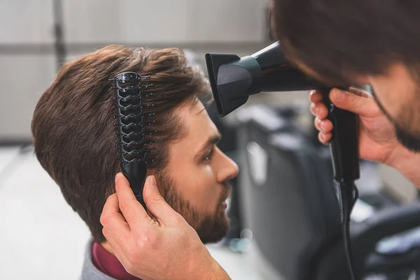 Barber using hairdryer at beauty salon - Stock Image - Everypixel Barber using hairdryer at beauty salon - Stock Image - Everypixel