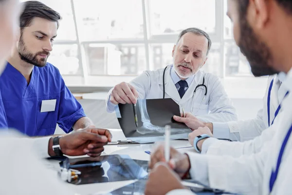 Equipe médica habilidosa discutindo foto de raio-x — Fotografia de Stock