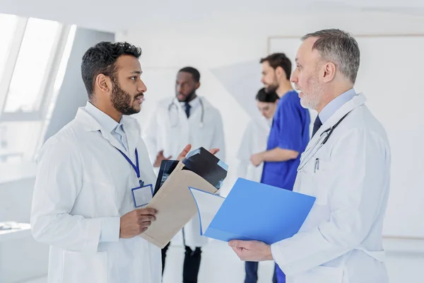 Médico jovem pedindo conselhos no médico geral sênior — Fotografia de Stock