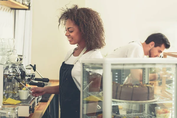 Smilende barista tilbereder deilig kaffe i kafeteriaen – stockfoto