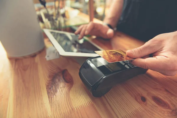 Barista pořizování kreditní karty provádět platby za návštěvníka — Stock fotografie