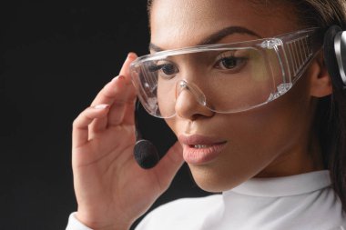 Kulaklıklı mikrofon seti ile çalışan düşünceli Afrika kadın