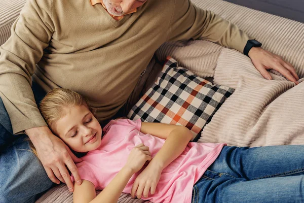 Abuelo mayor ayudando a su nieta a dormir — Foto de Stock