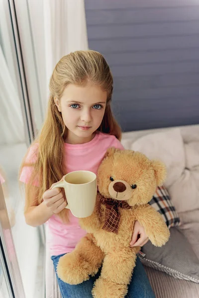 Niño inocente tomando té en la sala de estar — Foto de Stock