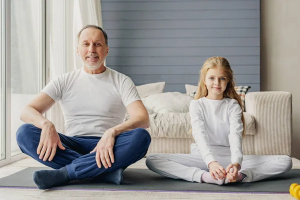 Alegre familia haciendo ejercicio juntos en casa — Foto de Stock