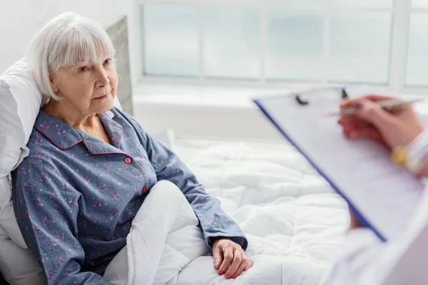 Physician questioning old woman in hospital — Stock Photo, Image
