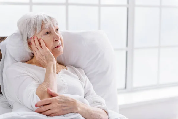 Worried patient reclining in cot at clinic — Stock Photo, Image