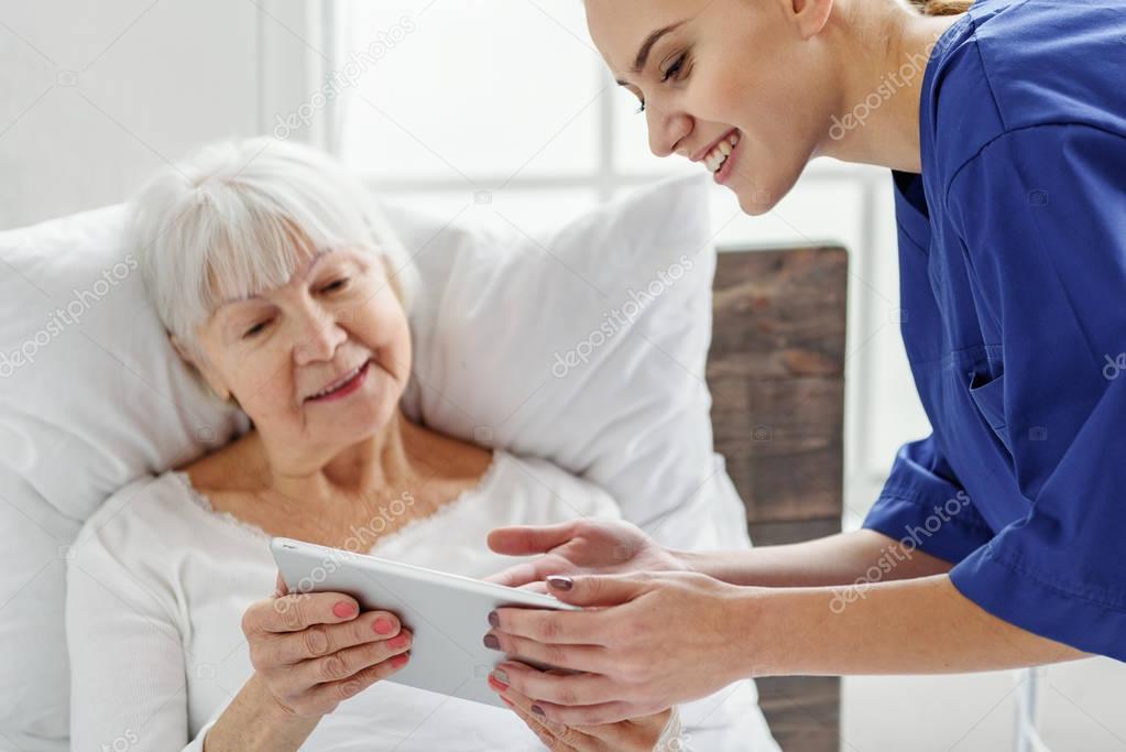 Outgoing physician helping to use tablet
