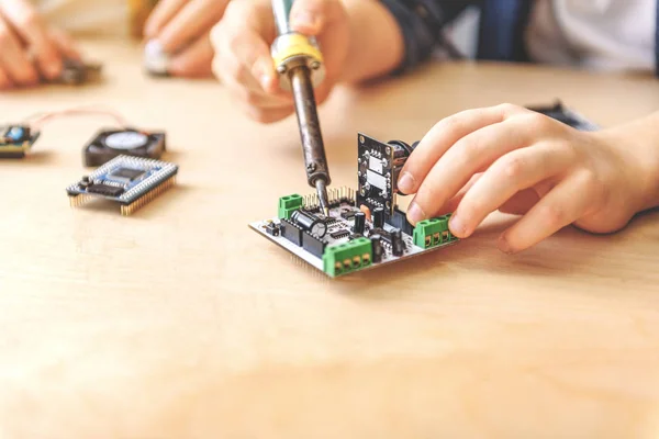 Chico reparando pequeño detalle técnico — Foto de Stock