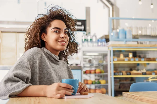 Neşeli genç kadın ile sıcak içecek rahatlatıcı