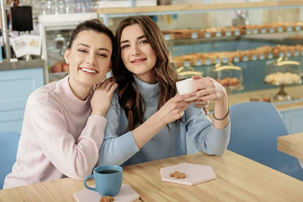 Mujeres jóvenes hilarantes juntos en la cafetería — Foto de Stock