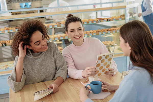Hilarious smiling young women in confectionery