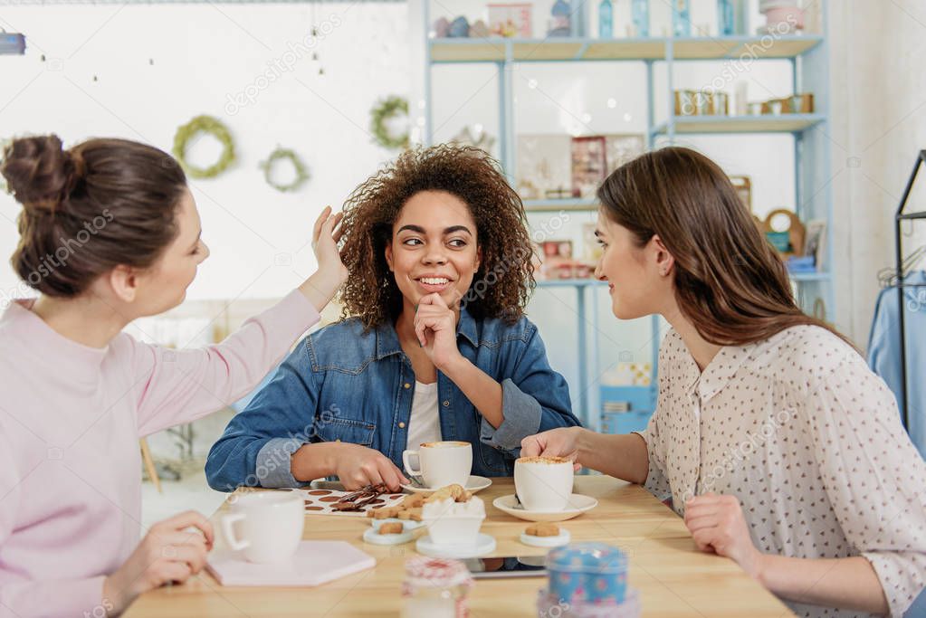 Smiling young women talking in cafe