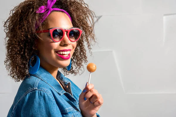 Utgående ung kvinna håller lollipop — Stockfoto