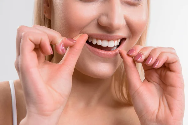 Reiniging van de tanden door tandheelkundige floss meisje — Stockfoto