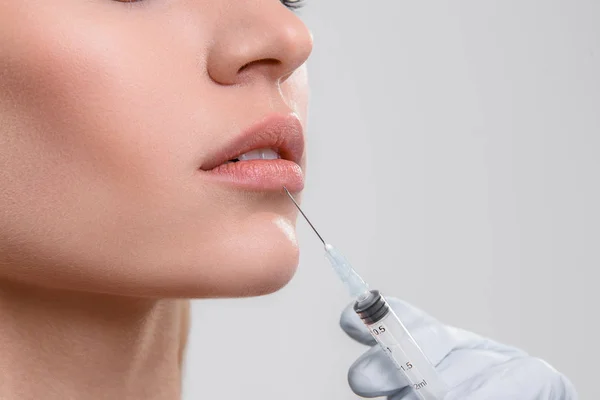 Médico injetando líquido nos lábios femininos — Fotografia de Stock
