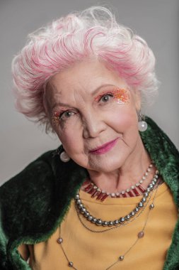 Kameraya bakarak yaşlı gülümseyen modeli