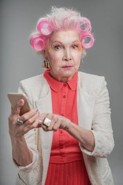 Cep telefonu tutan trendy şık yaşlı kadın