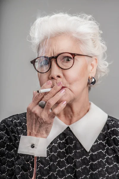 Senhora idosa na moda posando com charuto — Fotografia de Stock