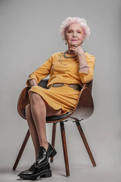 Расслабленная уверенная в себе пожилая женщина позирует перед камерой — стоковое фото
