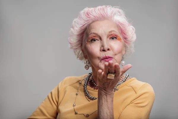 Happy elderly female posing with bright make-up — Stock Photo, Image