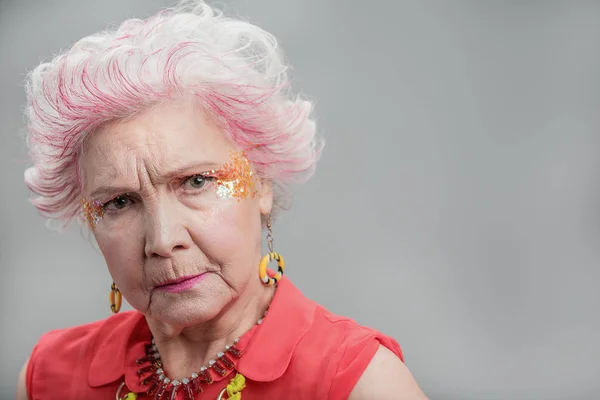 Недовольная пожилая стильная леди с макияжем — стоковое фото