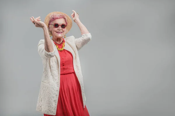 Счастливая красивая пожилая дама в солнцезащитных очках и шляпе — стоковое фото
