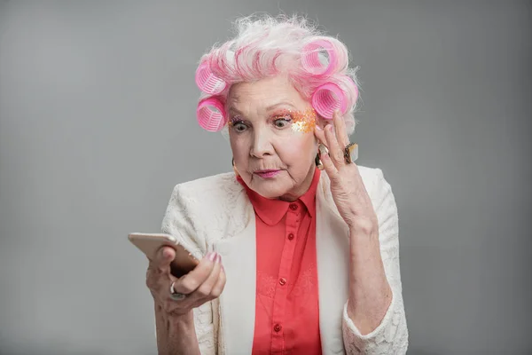 Senior woman with pink hair reading message — Stock Photo, Image