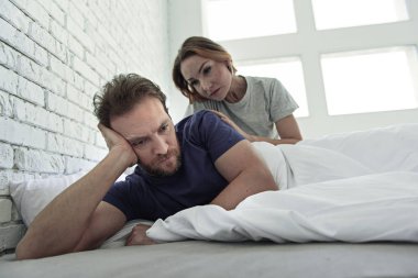 Upset couple lying in bed clipart