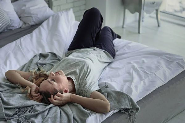 Sorgliga kvinna liggande på sänggavlar — Stockfoto