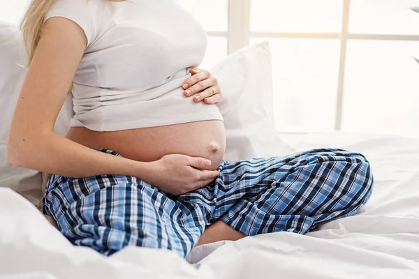 Pregnant woman gently touching her belly by hands — Stock Photo, Image