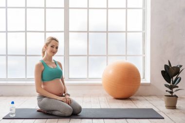 Hamile kadın germe sonra dinlenme gülümseyen