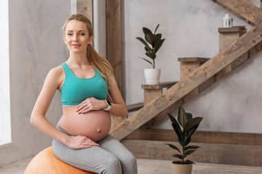 Gelecekte anne büyük göbek ile spor giyim gülümseyen