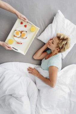 Mutlu kadın yatakta yemeye hazır