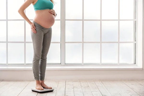 Alegre futura madre pesándose — Foto de Stock