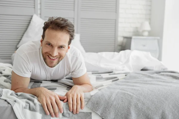 Tipo despreocupado descansando en el dormitorio — Foto de Stock