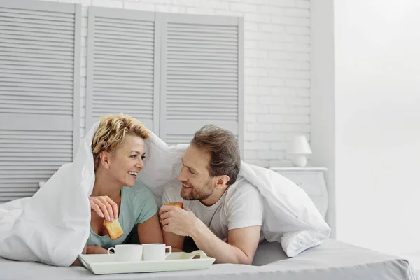 性格开朗的已婚的夫妇在卧室吃东西 — 图库照片
