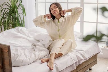 Yumuşak yatağa oturan sakin kadın