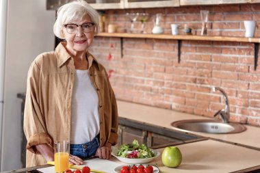 Kahvaltı hazırlarken mutlu üst düzey Bayan