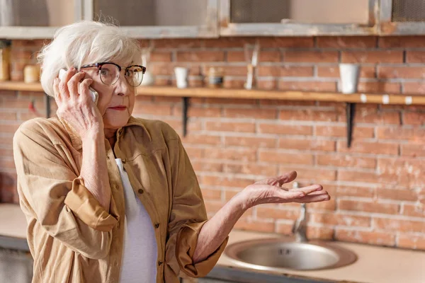 Загадочная пожилая леди разговаривает по мобильному телефону — стоковое фото