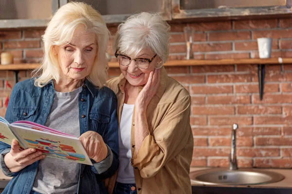 Dos señoras mayores decidiendo qué cocinar — Foto de Stock