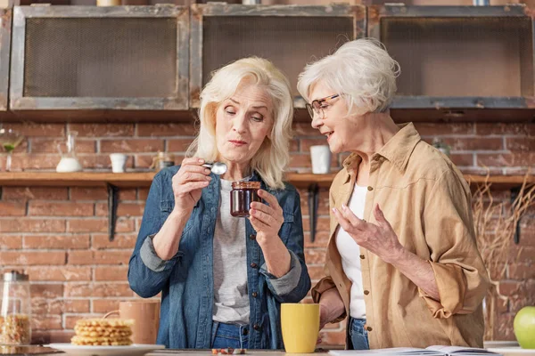 Веселі старші дами діляться досвідом приготування їжі — стокове фото