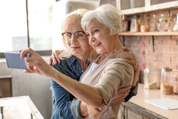 Alegre ancianas haciendo selfie en la cocina —  Fotos de Stock