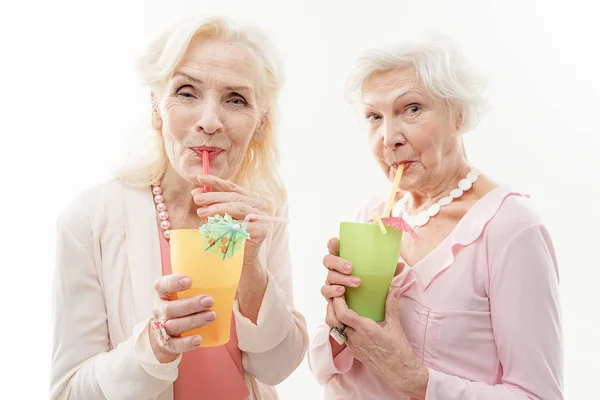 Alegre señoras mayores disfrutando de bebidas exóticas — Foto de Stock