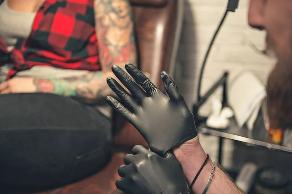 Man wearing gloves before creating picure on female body — Stock Photo, Image