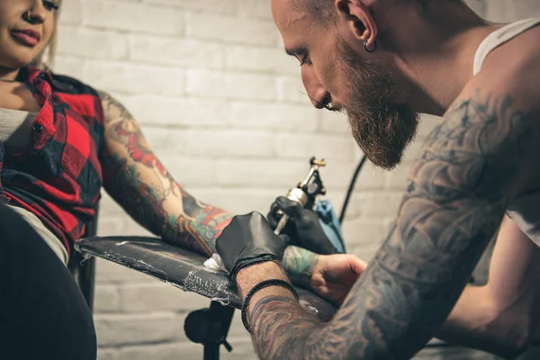 Calm male creating picture on female arm — Stock Photo, Image